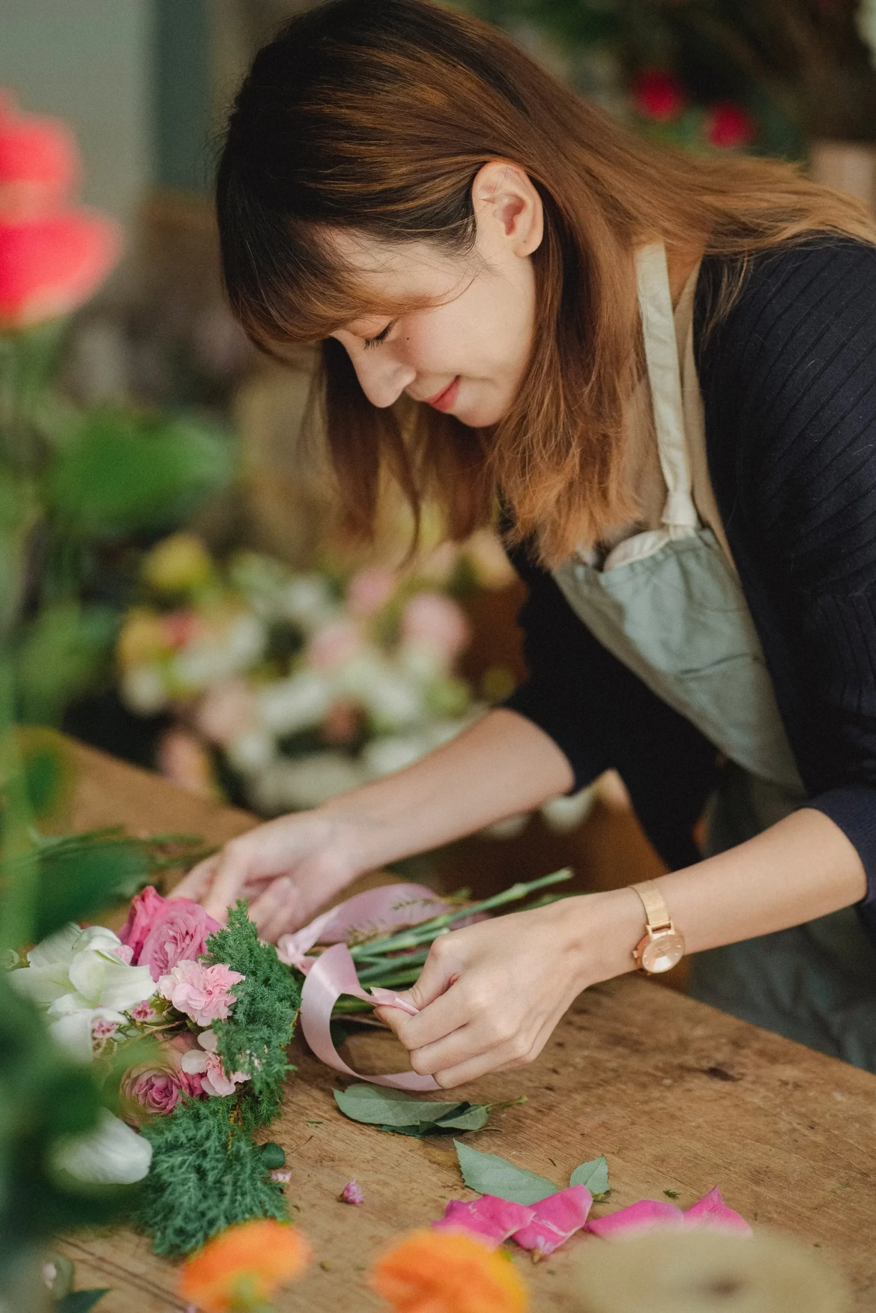 A person placing flowers on a table
